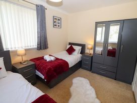A bedroom with two single beds and a wardrobe at Willow cottage in Seahouses