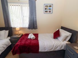 A bedroom with two beds and a nightstand at Willow cottage Seahouses