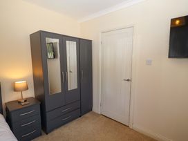 A bedroom with a wardrobe and bedside table at Willow cottage in Seahouses