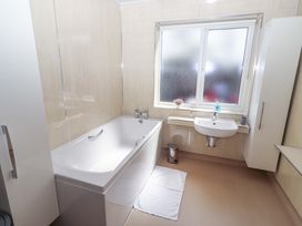 A bathroom with a bathtub and sink at Willow cottage in Seahouses