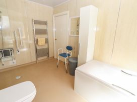 A bathroom with a shower, toilet, and a towel rack at Willow cottage in Seahouses