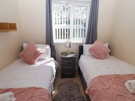 A bedroom with two single beds and a nightstand at Willow cottage in Seahouses