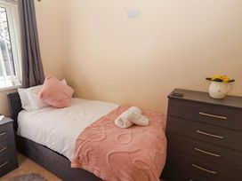 A bedroom with a bed and dresser at Willow cottage in Seahouses