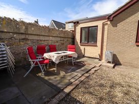 An outdoor area with a table and chairs at Willow cottage in Seahouses