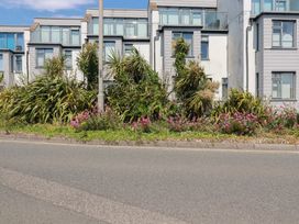 A view of buildings and plants along a road at Cwtch Treth in Newquay
