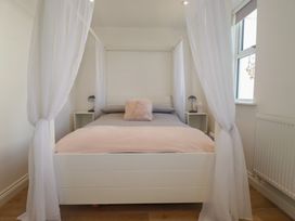 A bedroom with a bed and lamp at Cwtch Treth in Newquay