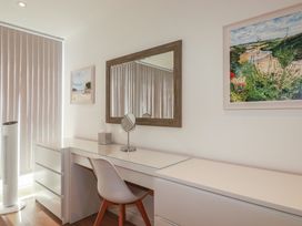 A home office with a desk, mirror, and window at Cwtch Treth in Newquay