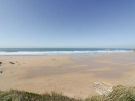 A beach with sand and waves at Cwtch Treth in Newquay