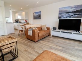 A living room with a sofa and television at Cwtch Treth in Newquay