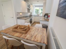 A kitchen with a dining table and chairs at Cwtch Treth in Newquay