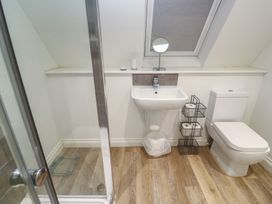 A bathroom with a shower, sink, and toilet at Cwtch Treth in Newquay