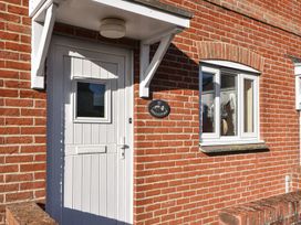An entrance door and a window of a cottage at Mead Cottage in Bridport