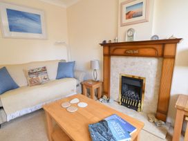 A living room with a fireplace and sofa at Mead Cottage in Bridport