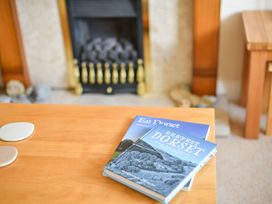 A coffee table with books on top in the living room at Mead Cottage Bridport