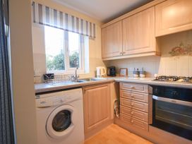A kitchen with appliances and cabinets at Mead Cottage in Bridport