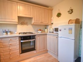 A kitchen with cabinetry, stove, fridge, and microwave at Mead Cottage in Bridport