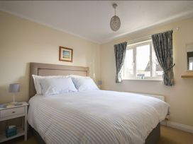 A bedroom with a bed and a nightstand at Mead Cottage in Bridport
