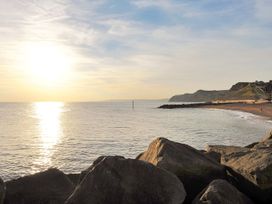 A beach view with rocks and sunset at Mead Cottage in Bridport