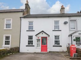 A house with a red door and windows at The Old Post Office in Whitehaven