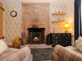 A living room with a fireplace and furniture at The Old Post Office in Whitehaven