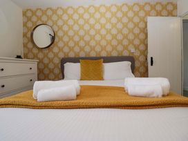 A bedroom with a bed and towels at The Old Post Office in Whitehaven
