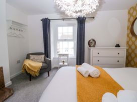 A bedroom with a bed, chair, and window at The Old Post Office in Whitehaven