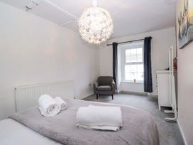 A bedroom with a bed, chair, and window at The Old Post Office in Whitehaven