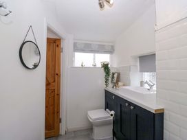 A bathroom with a sink, toilet, and mirror at The Old Post Office in Whitehaven