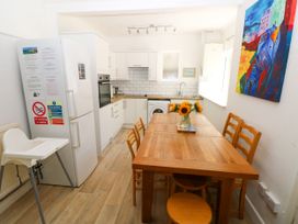 A kitchen with a dining table and appliances at 3 Edward Street Tenby