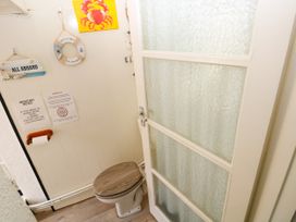 A bathroom with a toilet and wall decorations at 3 Edward Street in Tenby