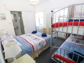 A bedroom with a double bed and bunk bed at 3 Edward Street Tenby
