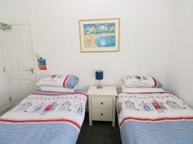 A bedroom with two beds and a bedside table at 3 Edward Street, Tenby
