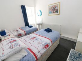 A bedroom with two beds and a sink at 3 Edward Street Tenby