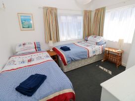 A bedroom with two beds and a bedside table at 3 Edward Street, Tenby