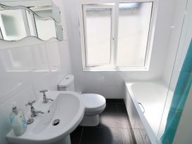 A bathroom with a sink, toilet, bathtub, and window at 3 Edward Street, Tenby
