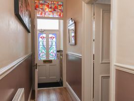 A hallway with a stained glass door and mirror at 30 Prospect Hill in Whitby