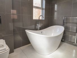 A bathroom with a bathtub and towel rail at 30 Prospect Hill in Whitby
