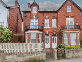 A brick building with multiple windows and a pathway at 30 Prospect Hill Whitby