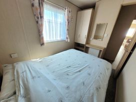 A bedroom with a bed and wardrobe at St Osyth- Sleeps8-freeparking-wifi-holidaypark Clacton-On-Sea