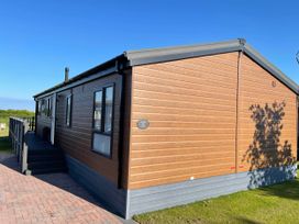 An exterior view of a lodge with a deck area at Yorkshire View Lodge in Wilberfoss