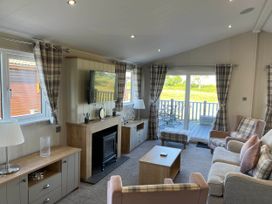 A living room with a television and seating area at Yorkshire View Lodge in Wilberfoss