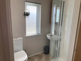 A bathroom with a toilet, shower, and sink at Yorkshire view lodge Wilberfoss
