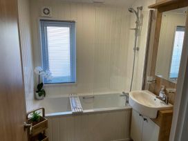 A bathroom with a bath tub, sink, and shower at Yorkshire view lodge Wilberfoss