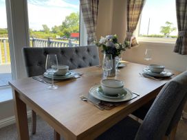 A dining room with a table set for three at Yorkshire view lodge in Wilberfoss
