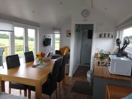 A living room with a dining table and sofa at Cleeves Cabins 2, Arran Luxury Lodge with hot tub in St. John's Town Of Dalry