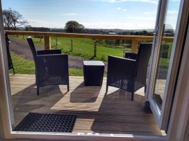 An outdoor seating area with two chairs and a table at Cleeves Cabins 2, Arran Luxury Lodge with hot tub, St. John's Town Of Dalry
