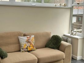 A sofa with a pillow and a radiator at 3 Bed House - Sleeps 6 - Parking - Garden - Wifi Glynneath