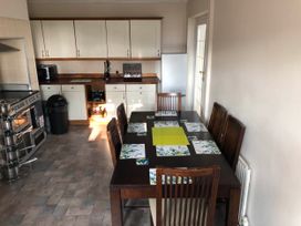 A kitchen with a dining table and chairs at 3 Bed House - Sleeps 6 - Parking - Garden - Wifi Glynneath