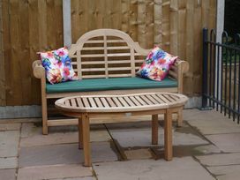A garden with a wooden bench and a table at Cottage - Sleeps 2 - Garden in Coleford