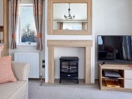 A living room with a fireplace and television at 2 Bed Lodge Sleeps 4 - Pet Welcome - Fireplace, Cirencester